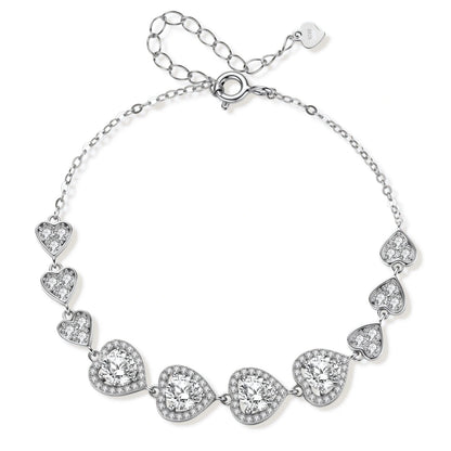 Sterling silver bracelet with graduated heart-shaped links and sparkling moissanite stones in VVS1 clarity on white background.