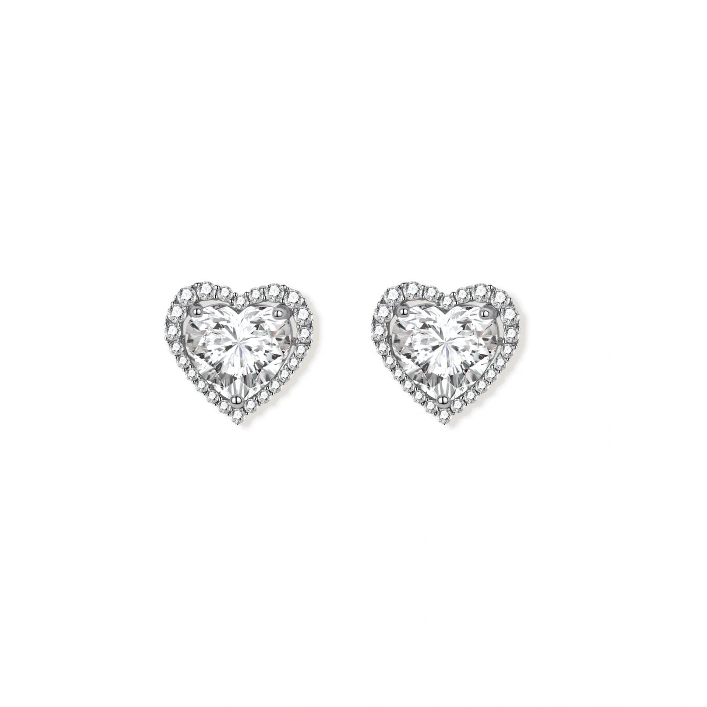 Close-up of heart-shaped moissanite stud earrings in sterling silver halo setting on cream background.