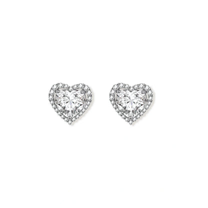 Close-up of heart-shaped moissanite stud earrings in sterling silver halo setting on cream background.