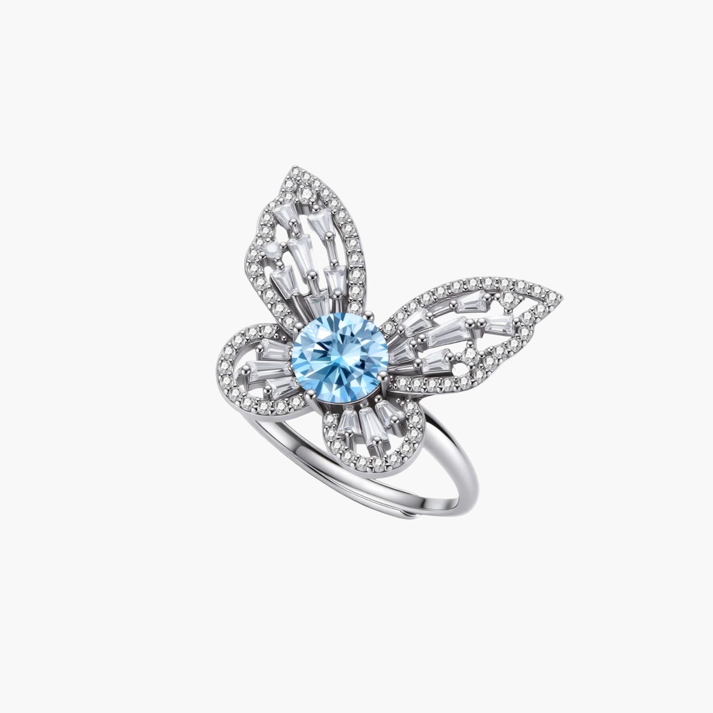 Sterling silver ring with blue moissanite center stone surrounded by clear stones in butterfly wing pattern on white background